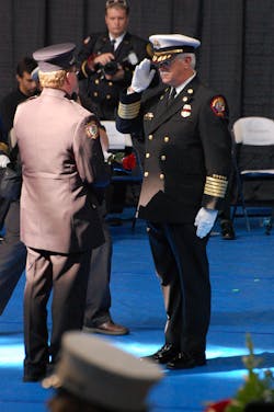 A flag and rose are handed to a presenter that would be handed to the family of a fallen firefighter. A flag and rose are handed to a presenter that would be handed to the family of a fallen firefighter.