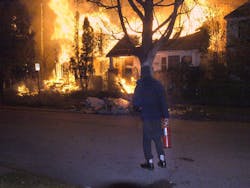 A frustrated resident waiting for companies to arrive, watches as three vacant houses burn on the East Side. A frustrated resident waiting for companies to arrive, watches as three vacant houses burn on the East Side.