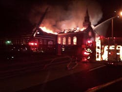 A four-alarm fire is tackled in Baltimore on Friday.