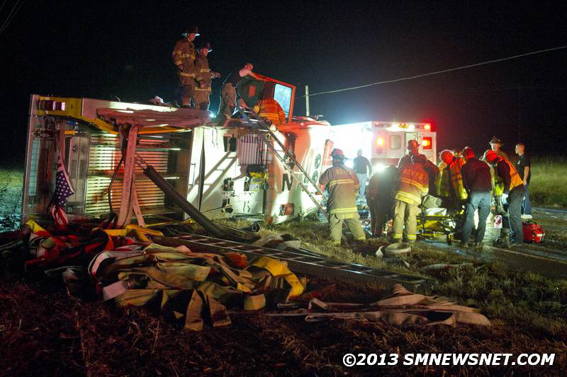 Firefighters work at the scene of the rollover.