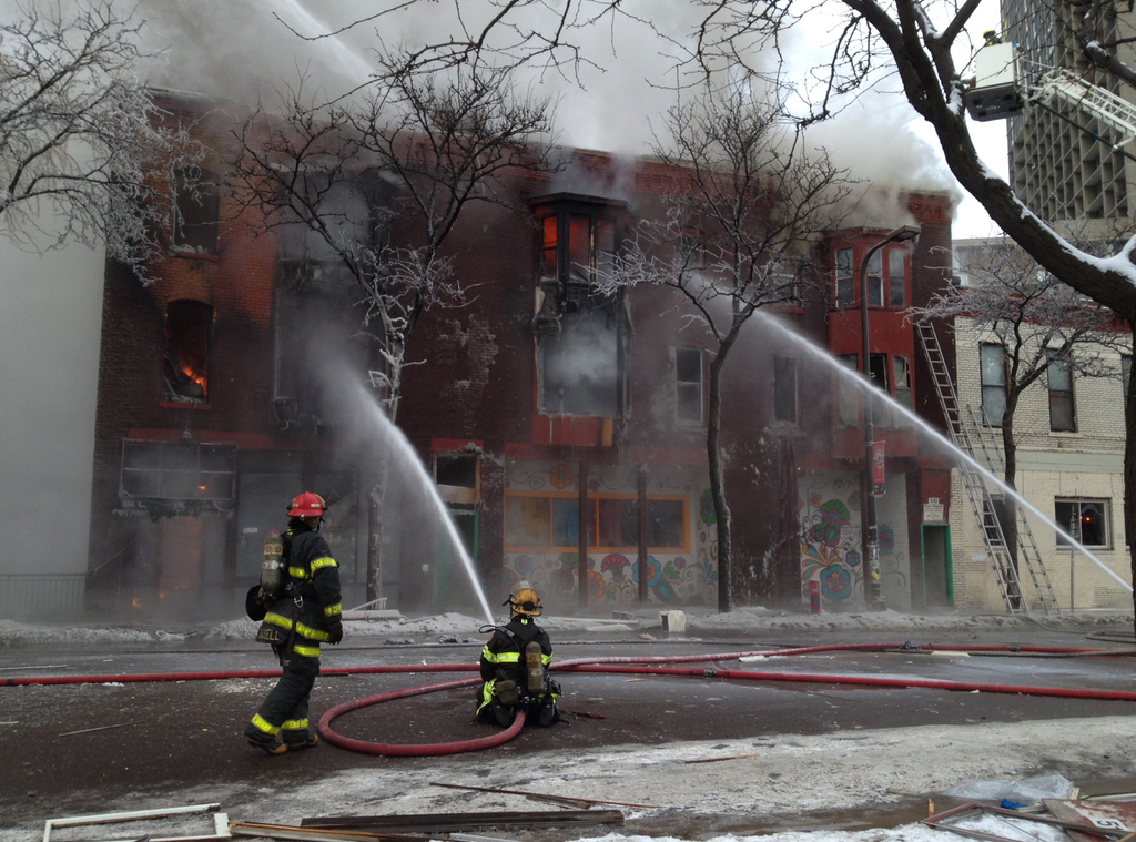 Firefighters pour water into the burning building.