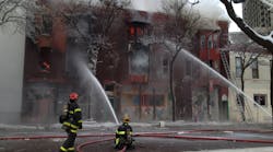 Firefighters pour water into the burning building.