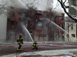 Firefighters pour water into the burning building.