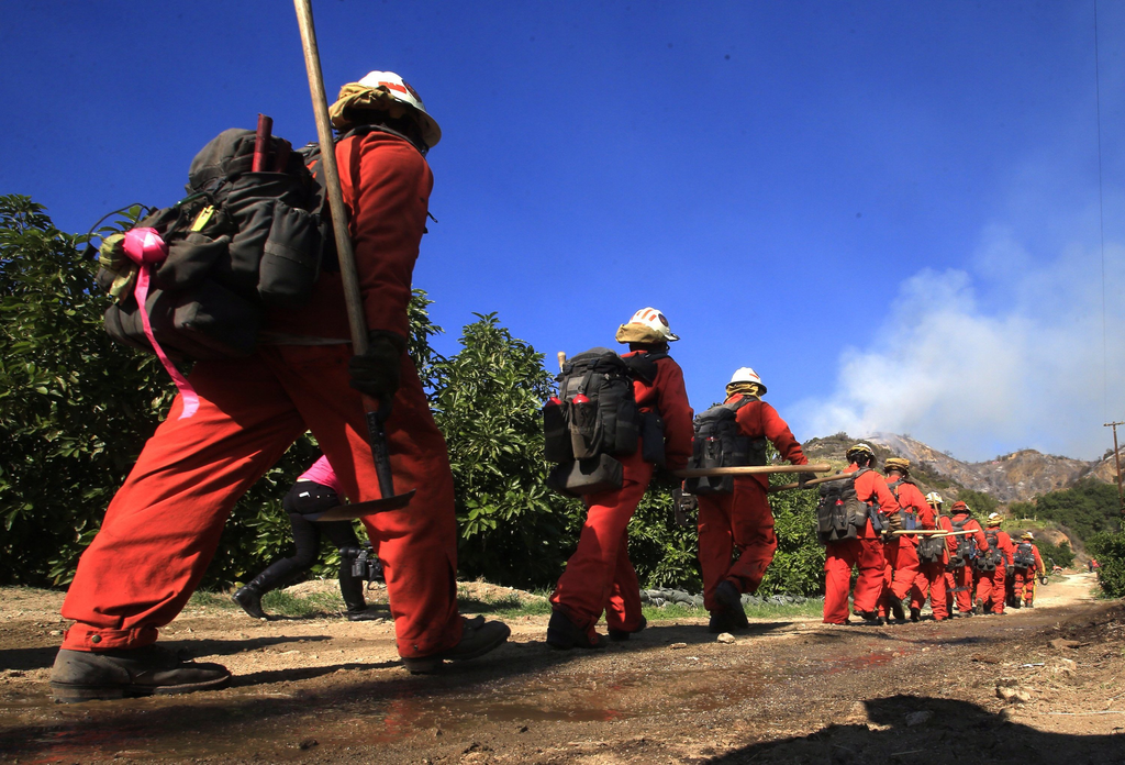 An inmate hand crew heads up a fire access road to fight the Colby fire in Glendora, Calif., on Thursday, Jan. 16, 2014.