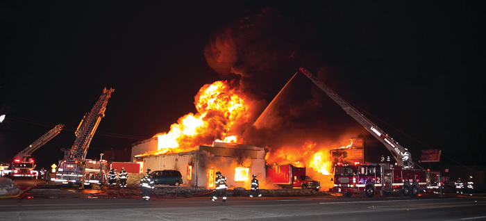Northlake Truck 803 and Leyden Quint 133 set up as Franklin Park Ladder 2 applies water and firefighters lay hoselines.