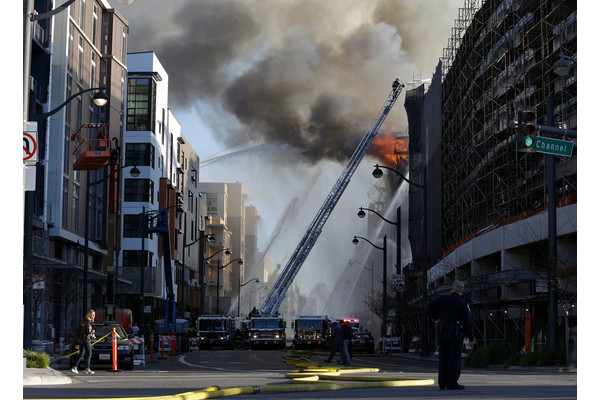 Firefighters battle a fire burning in San Francisco, Tuesday, March 11, 2014.
