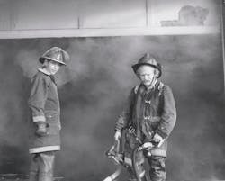 AUG. 23, 1975 – Station 68 Captain Alan Maas and Volunteer Captain Joe Gay at a 2-11 warehouse fire at SW Freeway and Hillcroft. AUG. 23, 1975 – Station 68 Captain Alan Maas and Volunteer Captain Joe Gay at a 2-11 warehouse fire at SW Freeway and Hillcroft.