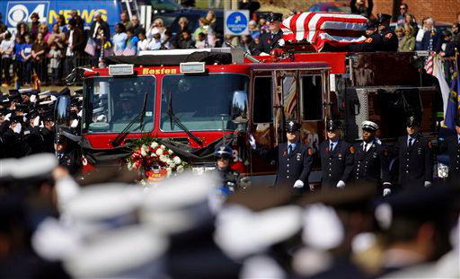 The casket of Firefighter Michael Kennedy moves through the street.