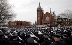 Firefighters salute as the casket is carried from the church.