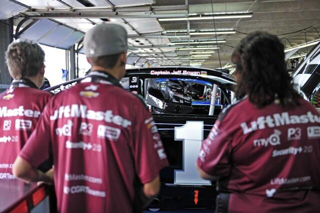 Members of the LiftMaster crew look at Jaime McMurray's car where Capt. Jeffrey Bowen's name added above the passenger door.