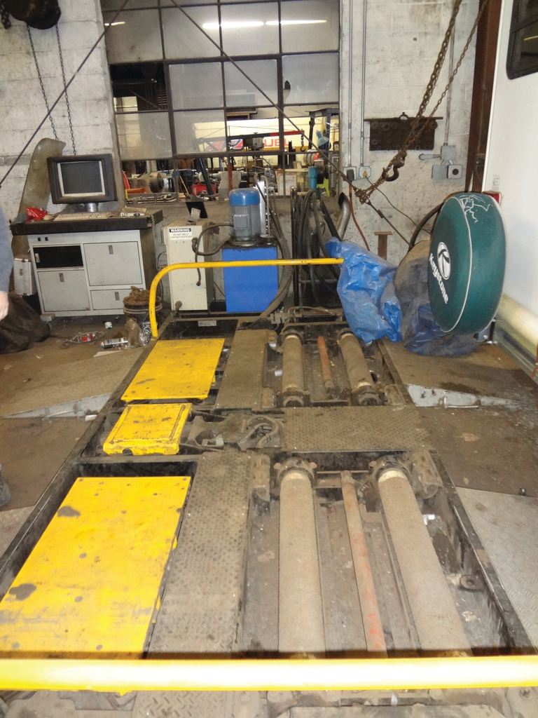 The machine is made up of several components. There is a desk with a computer screen and a printer. To the immediate right of the desk is a computer that captures information. To the right of the computer&rsquo;s brain is a blue cylindrical machine; that is the hydraulic pump that powers the rollers and the yellow panels that act as shakers.