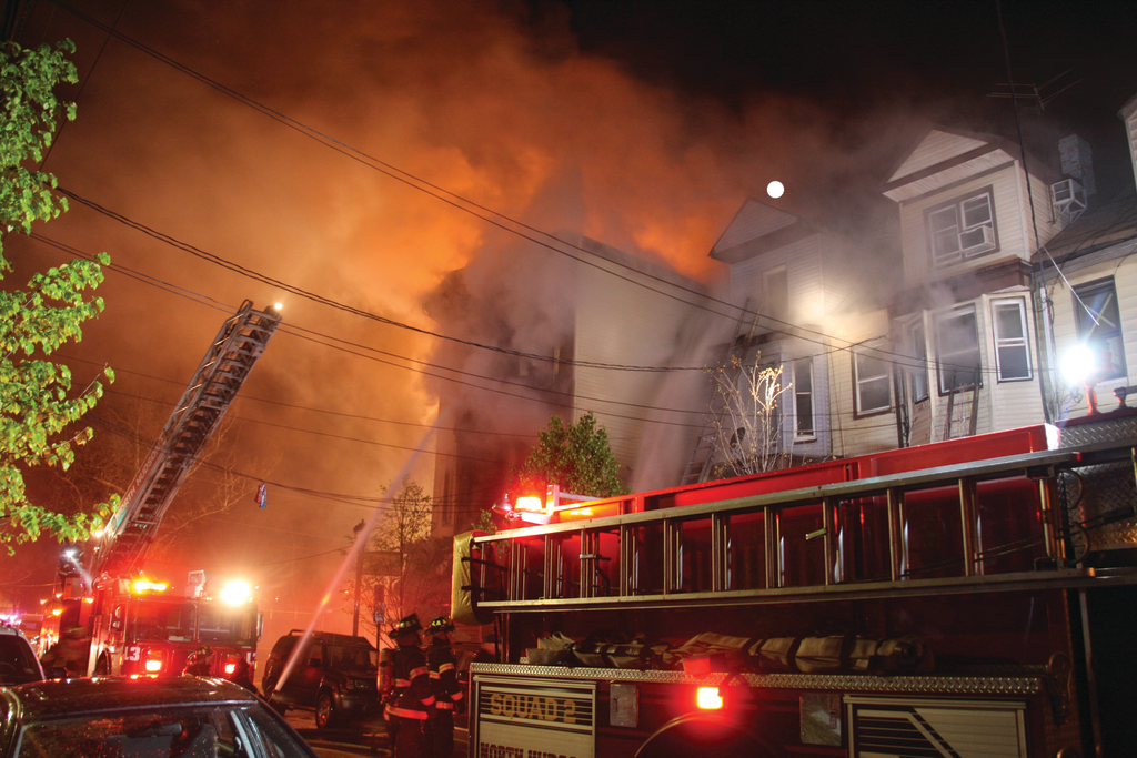 UNION CITY, NJ, MAY 6, 2014 &ndash; An early-morning fire started in a grocery store in a three-story wood-frame building. First-in units found heavy fire through openings in roll-down security gates in front of the store. The fire quickly rose up the voids in the original building and extended to a row of five attached 2-1/2-story occupied dwellings. Smoke was showing from the cockloft of two of the dwellings when the first-alarm units arrived. Approximately 40 residents were displaced. More than 100 firefighters from the North Hudson Regional Fire Department operated at the scene along with mutual aid units from Jersey City. One firefighter suffered a minor injury.