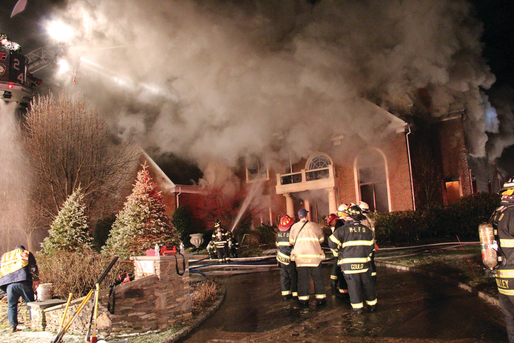 Photo 1: Heavy smoke was followed by fire coming through the roof (Photo 2) of the 5,000-square-foot house and a subsequent complete collapse.