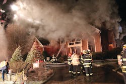 Photo 1: Heavy smoke was followed by fire coming through the roof (Photo 2) of the 5,000-square-foot house and a subsequent complete collapse.