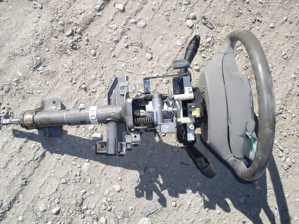 Looking at this steering column, the white plastic ball joint by the coiled spring is the column's tilt-adjustable joint. There may be a solid steel shaft below this tilt joint and a solid shaft above it connected to the steering wheel itself. The tilt joint, however, is generally a weak point of a column. If the column is to be totally cut through, this would be a great place to start.