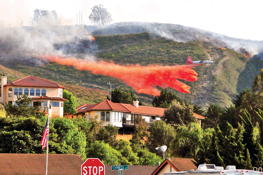 Air Tanker-910 (VLAT DC-10) drops a load of retardant to protect homes in the City of Lompoc, CA, on May 13, 2014. At the same time, structure-protection engines kept watch on the advance of the fire as part of a mutual aid structure-protection strike team.