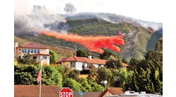 Air Tanker-910 (VLAT DC-10) drops a load of retardant to protect homes in the City of Lompoc, CA, on May 13, 2014. At the same time, structure-protection engines kept watch on the advance of the fire as part of a mutual aid structure-protection strike team.