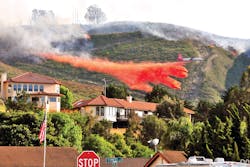 Air Tanker-910 (VLAT DC-10) drops a load of retardant to protect homes in the City of Lompoc, CA, on May 13, 2014. At the same time, structure-protection engines kept watch on the advance of the fire as part of a mutual aid structure-protection strike team.