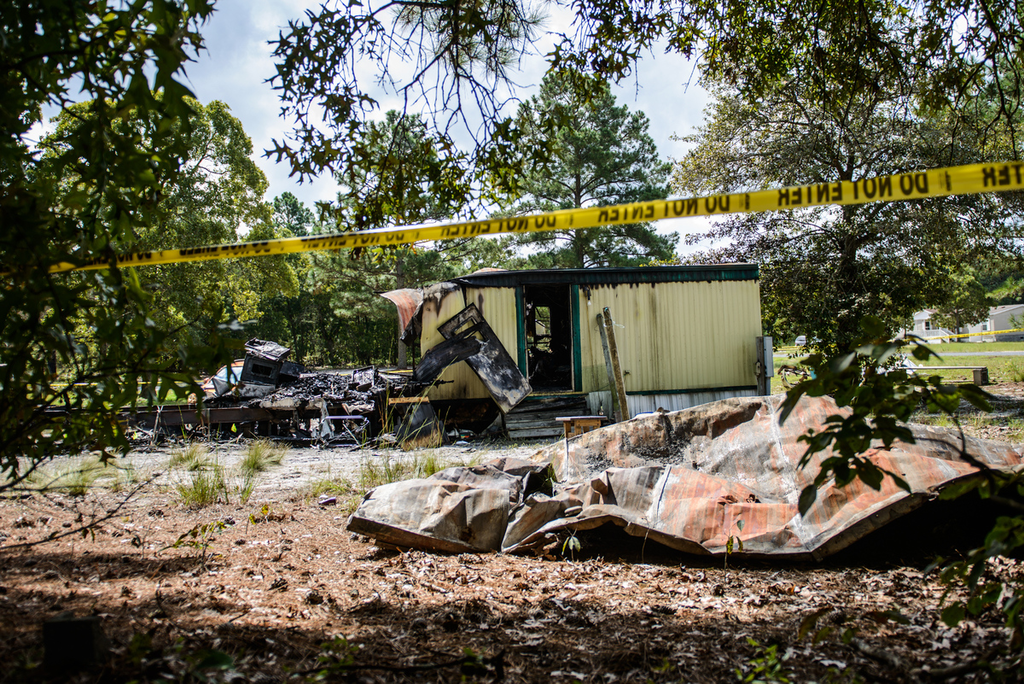 This Saturday, Aug. 30, 2014 photo shows the burned remains of a mobile home in Garland, N.C. An early Saturday fire killed six people inside, authorities said.