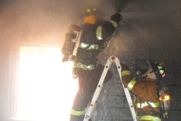 Photo 3: Many skills are new to the candidate and take time to build skills. Here, a pair of candidates work on stopping the flow from a sprinkler head with a pair of wooden chocks.