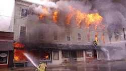 The time of the first page was 1:15 P.M. Ten minutes into the incident, only the Buckeye Block building’s second floor (Buckeye Hall auditorium) and third floor 3 (storage space) are well-involved. This view is of side C looking east toward side D. The time of the first page was 1:15 P.M. Ten minutes into the incident, only the Buckeye Block building’s second floor (Buckeye Hall auditorium) and third floor 3 (storage space) are well-involved. This view is of side C looking east toward side D.