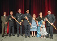The Firehouse&circledR; Magazine Heroism Awards program honored members of the Bryan, TX, Fire Department during the Opening Ceremonies at Firehouse Expo 2014 in Baltimore, MD, in July. From left to right: Bryan City Manager Kean Register; Assistant Chief Terry Barnett; Fire Chief Randy McGregor; Firefighter Mitchel Moran and his fiancee, Katy Garcia; Kara Mantey and Kanzie Mantey, wife and daughter of Firefighter Ricky Mantey; and Mantey. Lieutenant Greg Pickard was honored posthumously.