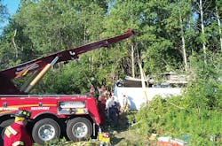 A heavy-duty wrecker was called in to lift a bus off of an accident victim. A heavy-duty wrecker was called in to lift a bus off of an accident victim.