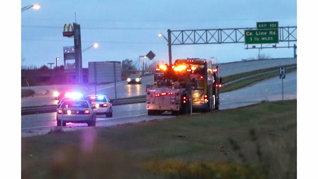 A double decker bus is towed north on I-65 in Greenwood, Ind., after the bus overturned early Tuesday, Oct. 14, 2014 after apparently swerving to avoid a minor crash, badly injuring one person and hurting more than a dozen others, officials said.