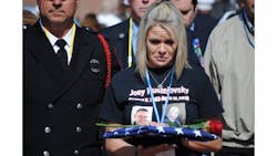 Kelly Pustejovsky holds the flag presented to her in memory of her husband, Joey, killed in the fertilizer plant blast in West.
