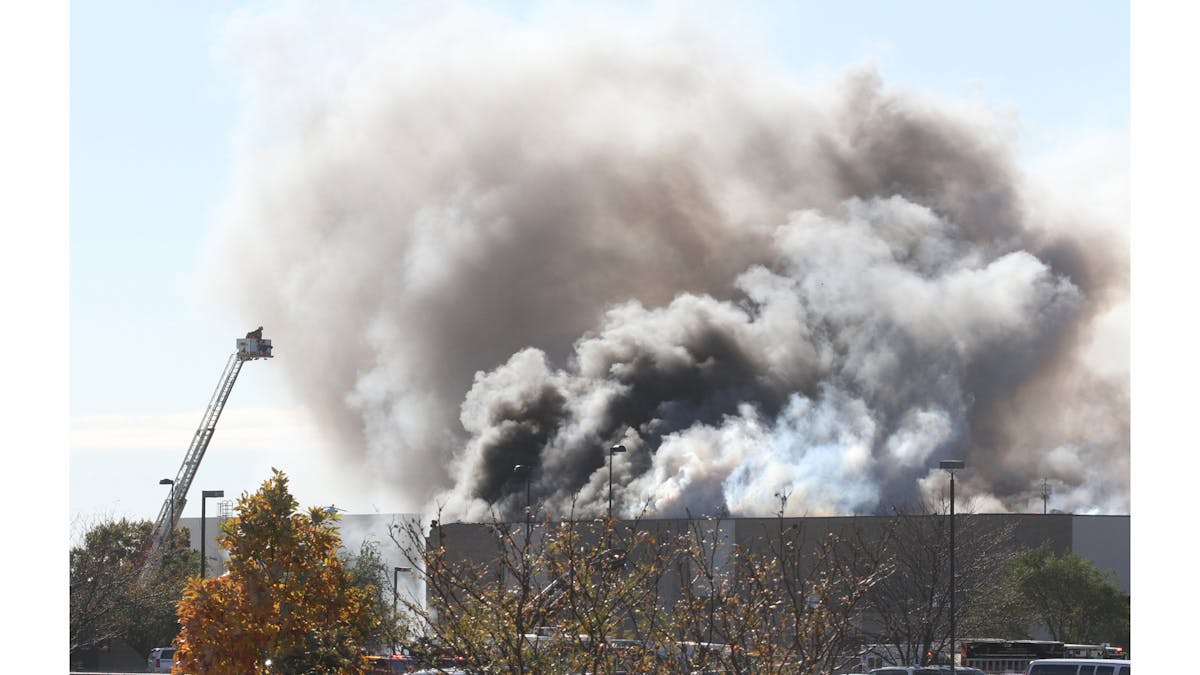 Smoke billows from a building at Mid-Continent Airport in Wichita, Kan., Thursday. Oct. 30, 2014, shortly after a small plane crashed into the building killing several people including the pilot.