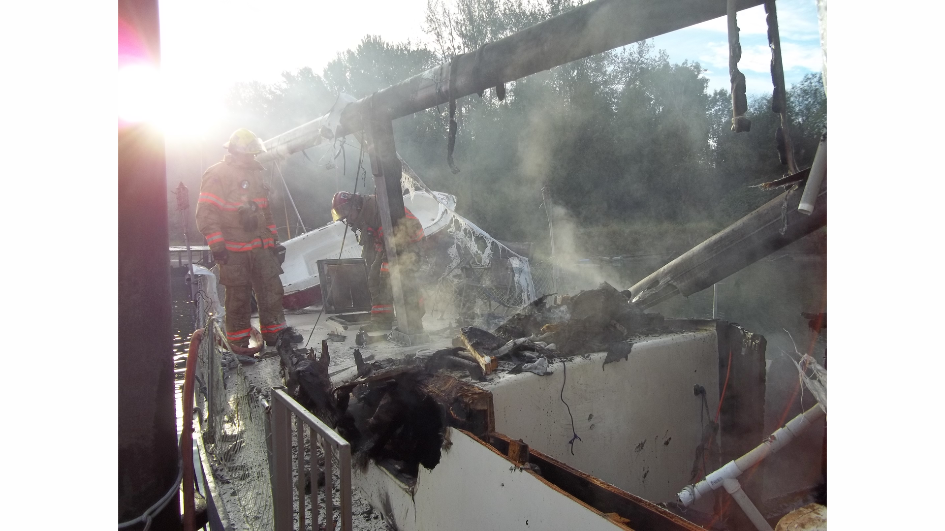 Portland firefighters look over the damaged boat.