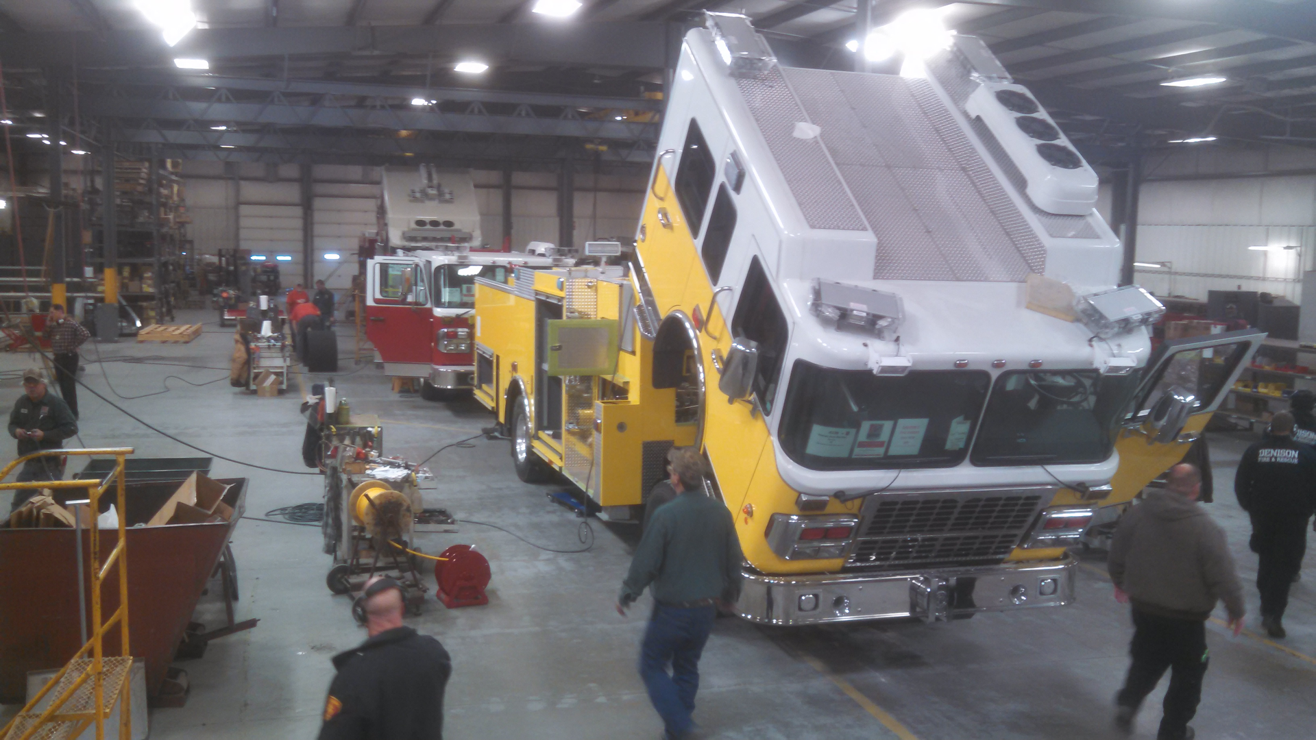 Smeal employees work on assembling a new aerial at its plant in Snyder, Neb. as firefighters tour the facility on Thursday.