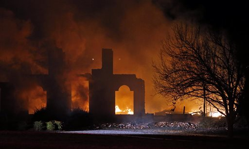 In this photo taken on Monday, Dec. 22, 2014, a smoldering fire is all that remains of a home belonging to Dallas Cowboys NFL football player Rolando McClain in Tuscaloosa, Ala.