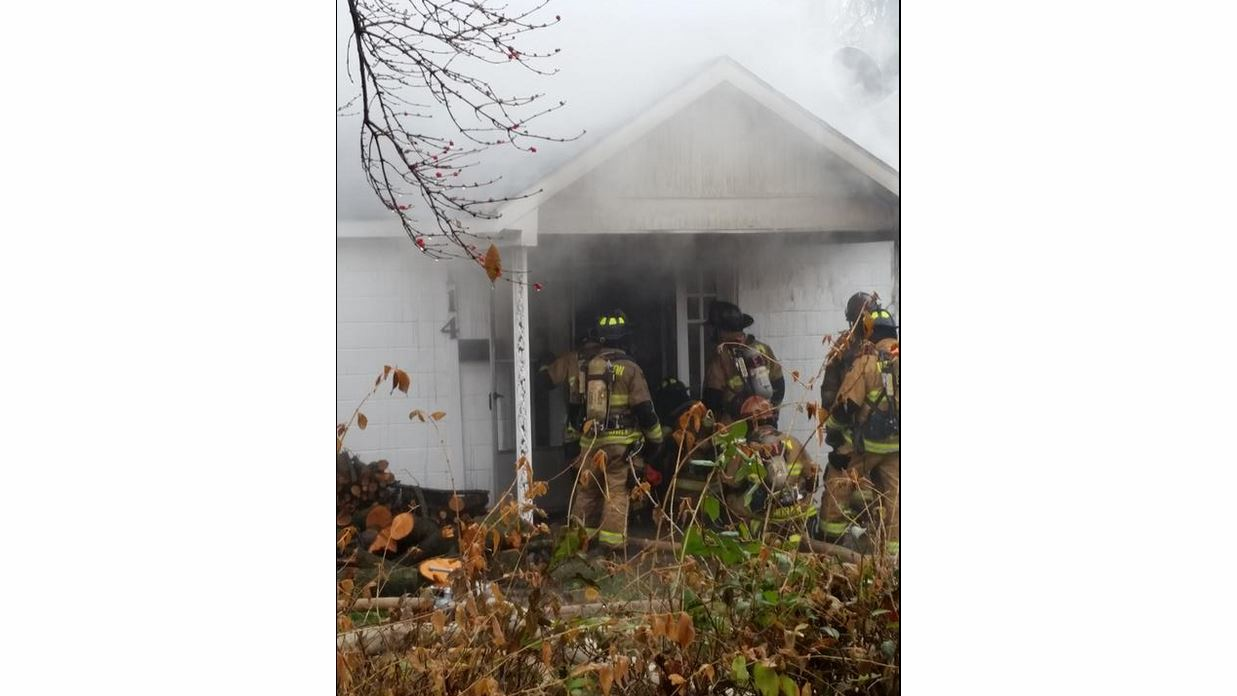 Lexington firefighters battle the fire from the front door of the home.