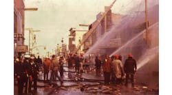 Firefighters and volunteers apply water to the buildings west of the State Theater to prevent spread farther to the east. All buildings on main between 5th and 6th avenues west of the theater were destroyed.