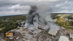 A photo taken from a drone several hours into the fire shows aerial streams in operation and large piles of vinyl scrap waiting to be processed.