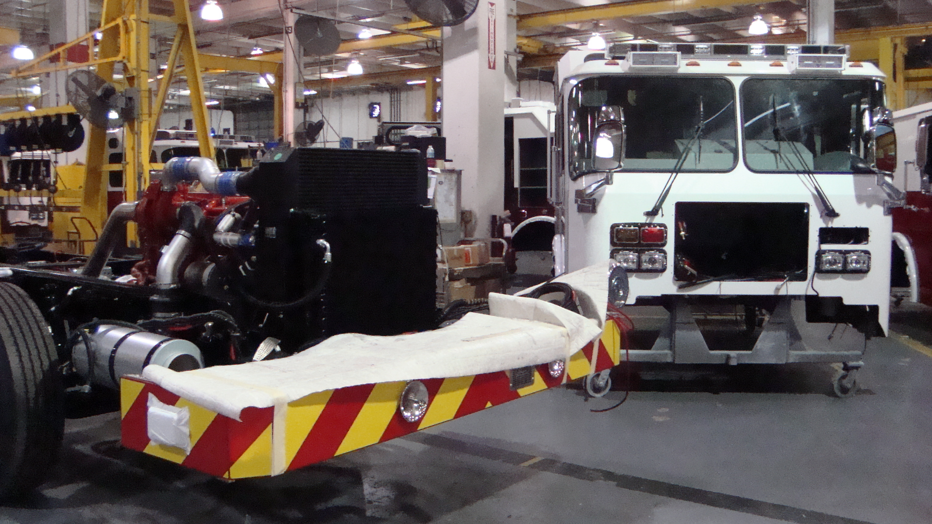 Near the middle of one of E-ONE's assembly plants, nearly completed cabs meet up with nearly completed chassis. After the two are mated, the cabs and chassis move further along the process, receiving additional components like bodies, tanks, pumps and aerial devices depending on the type of apparatus that's been ordered.