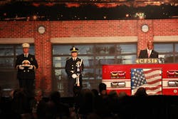 U.S. Fire Administrator Ernie Mitchell, at podium, remembers Glenn Gaines, while Fairfax County, Va. Chief Richie Bowers holds his helmet. U.S. Fire Administrator Ernie Mitchell, at podium, remembers Glenn Gaines, while Fairfax County, Va. Chief Richie Bowers holds his helmet.
