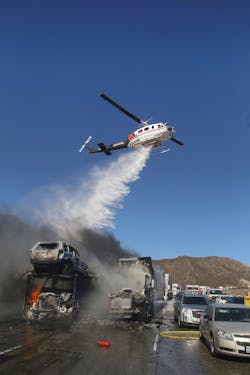 Helicopters drop water to douse burning vehicles. Helicopters drop water to douse burning vehicles.