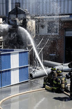 Prior to the collapse of the ductwork, firefighters operate a 2-1/2' hoseline off first-due Engine 967 to darken down the fire. Prior to the collapse of the ductwork, firefighters operate a 2-1/2' hoseline off first-due Engine 967 to darken down the fire.