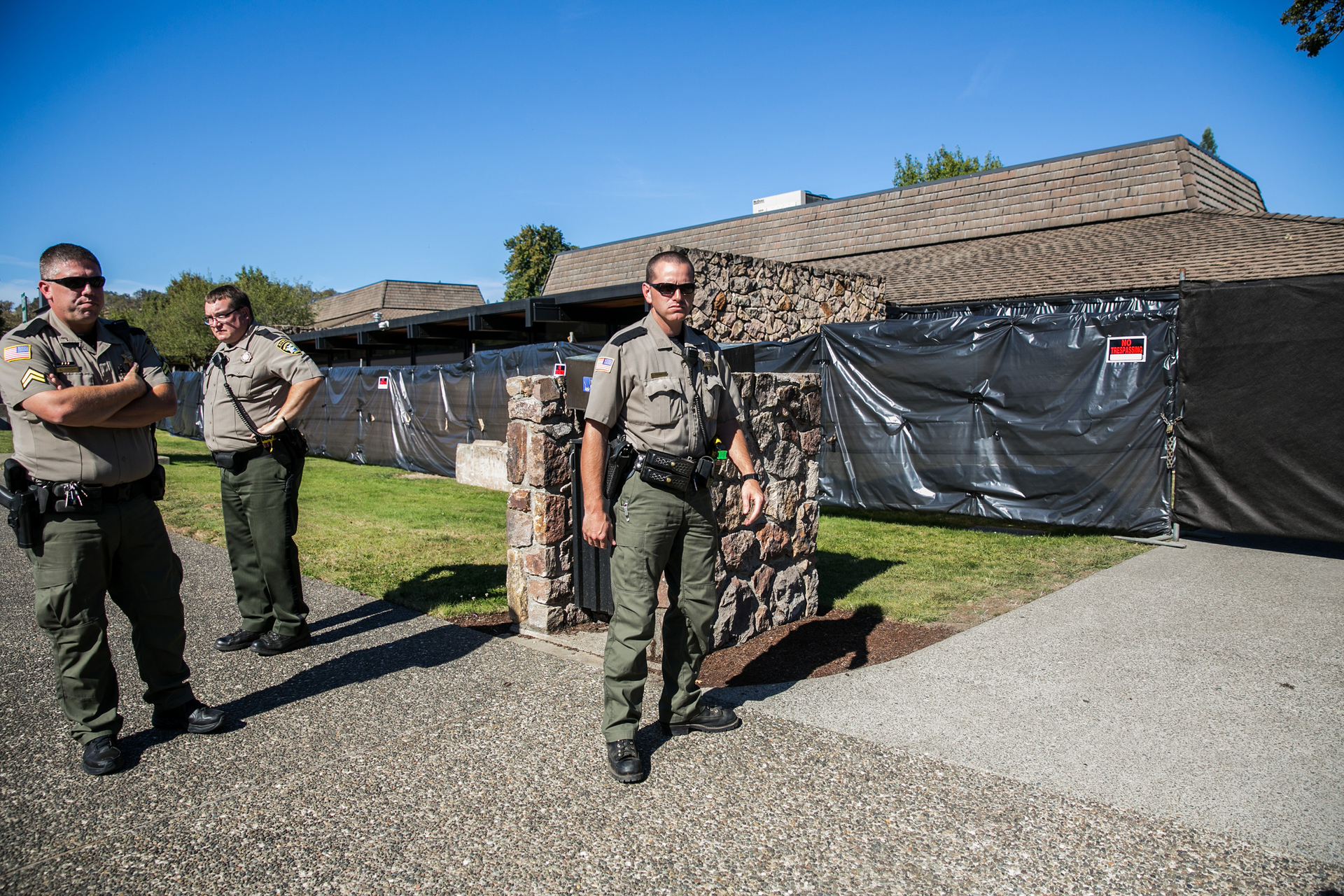 Officers stand outside a building where students were killed. The massacre is taking a toll on responders.