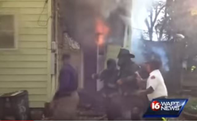 Two Jackson firefighters are removed from the burning home Tuesday morning.