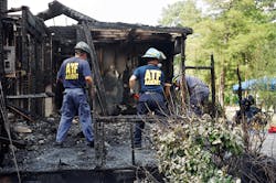 A team of ATF investigators work at a fire scene to determine the cause and origin. A team of ATF investigators work at a fire scene to determine the cause and origin.