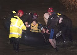 Fort Worth firefighters assist Tarrant County deputy Krystal Salazar from a rescue boat after she was pulled from a tree.
