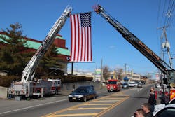 An American flag is hung between aerial ladders from the Cliffside Park and Fairview fire departments during Rubin&apos;s March 6 funeral.