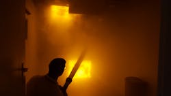 The man in the photo is not really in a fire building without turnout gear and SCBA. Rather, it's a simulated room and contents fire in BullEx's show booth and the man 'extinguishing' the fire is a representative of the company. BullEx's simulated fire board reacts to water streams, darkens down and eventually goes out with sufficient application of water. Smoke machines provide added scene realism. The man in the photo is not really in a fire building without turnout gear and SCBA. Rather, it's a simulated room and contents fire in BullEx's show booth and the man 'extinguishing' the fire is a representative of the company. BullEx's simulated fire board reacts to water streams, darkens down and eventually goes out with sufficient application of water. Smoke machines provide added scene realism.