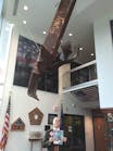 Charles Werner standing with a piece of 9/11 Memorial Steel, now suspended from the ceiling in CFD Station 10. He wrote about the trip to JFK Hangar 17 to take possession of the Memorial Steel in the September 2011 issue.