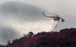 A helicopter drops water, aiding ground crews at Rancho La Scherpa, a mountain top retreat center, while working the Sherpa Fire in Santa Barbara County, Calif., on Friday, June 17, 2016.