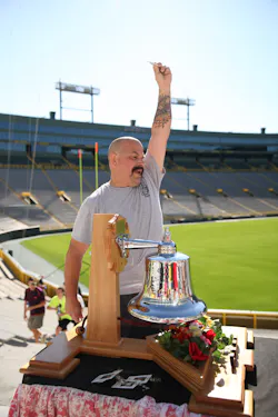 Pierce Manufacturing is hosting its fourth annual 9/11 Memorial Stair Climb at historic Lambeau Field on Saturday, September 10, 2016. All funds raised will benefit the National Fallen Firefighters Foundation (NFFF) and the families of fallen firefighters. Pictured is Pierce employee, Sam Boucher, as he rings a symbolic bell and raises a badge representing the fallen firefighter for whom he climbed at last year’s event.