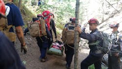 A Santa Fe (NM) Fire Department team trains using the Rapid Extraction Module (REM) in which a team of responders can extract a downed firefighter in a wildland setting. A Santa Fe (NM) Fire Department team trains using the Rapid Extraction Module (REM) in which a team of responders can extract a downed firefighter in a wildland setting.